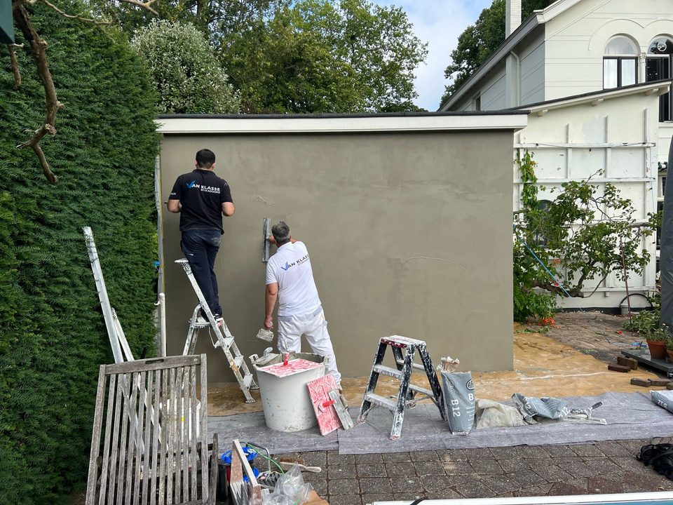 Team aan het werk op een tuinmuur