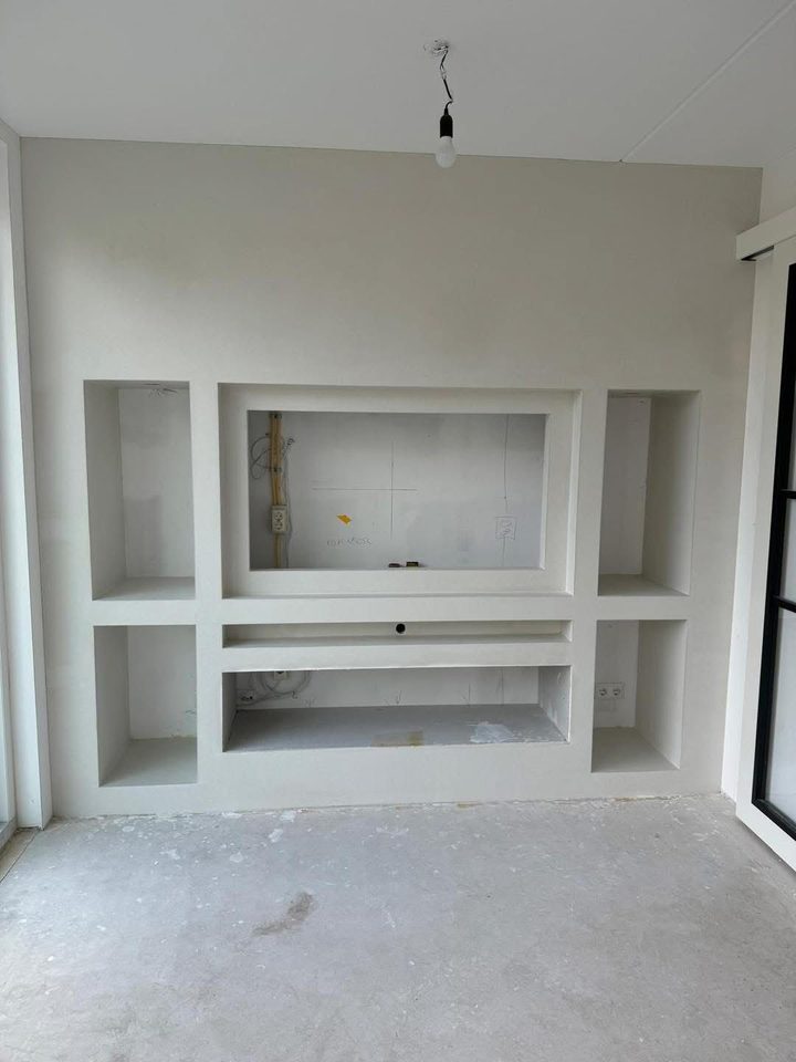 Strak afgewerkte witte wand met nissen na het stucwerk